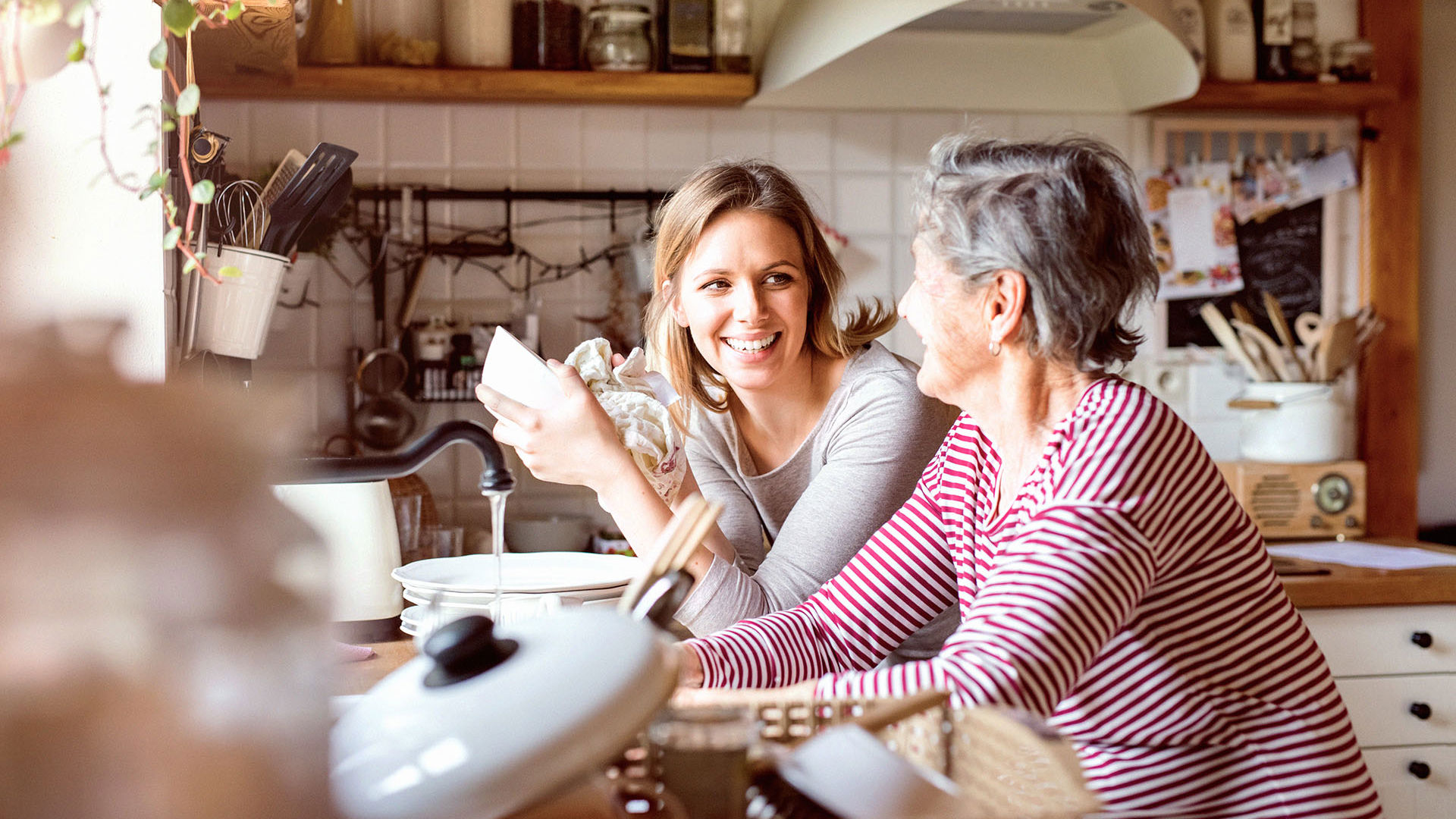 Grandmother donig the dishes with an adult granddaughter
