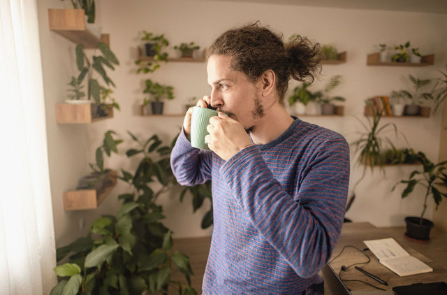 Man drinking his morning coffee on the phone to GMHBA health insurance