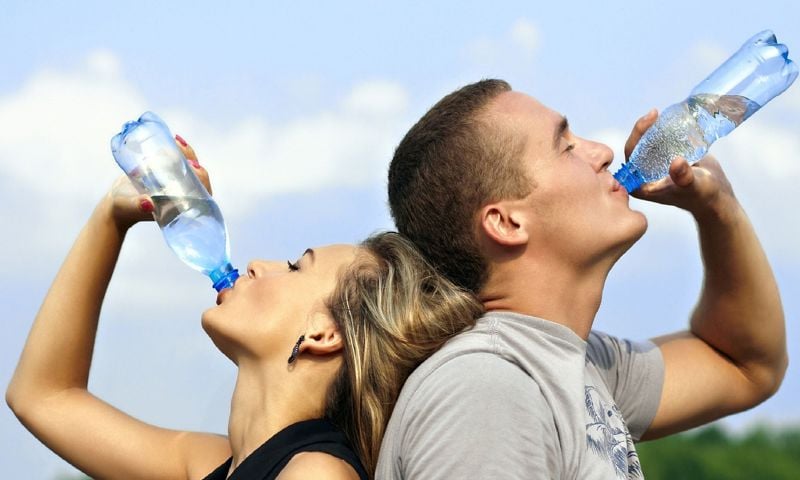 Couple drinking water with heads back