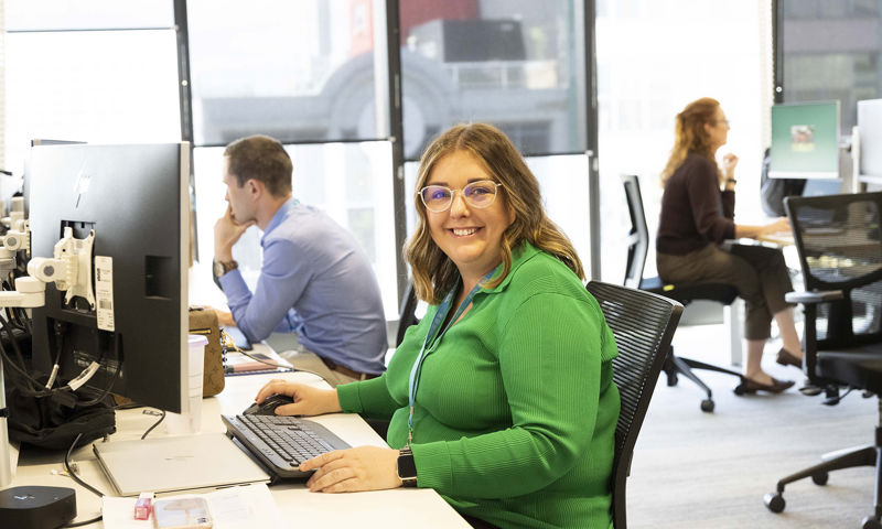 Happy GMHBA employee at desk in light filled office