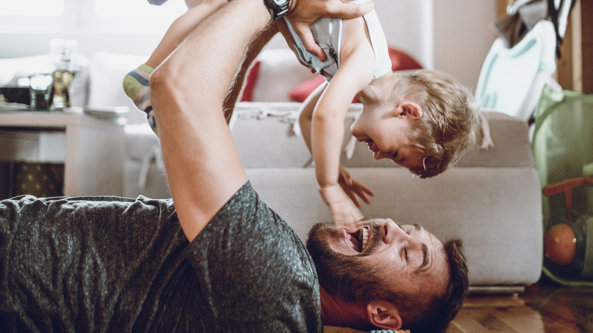 Dad lifting daugher and playing on the floor