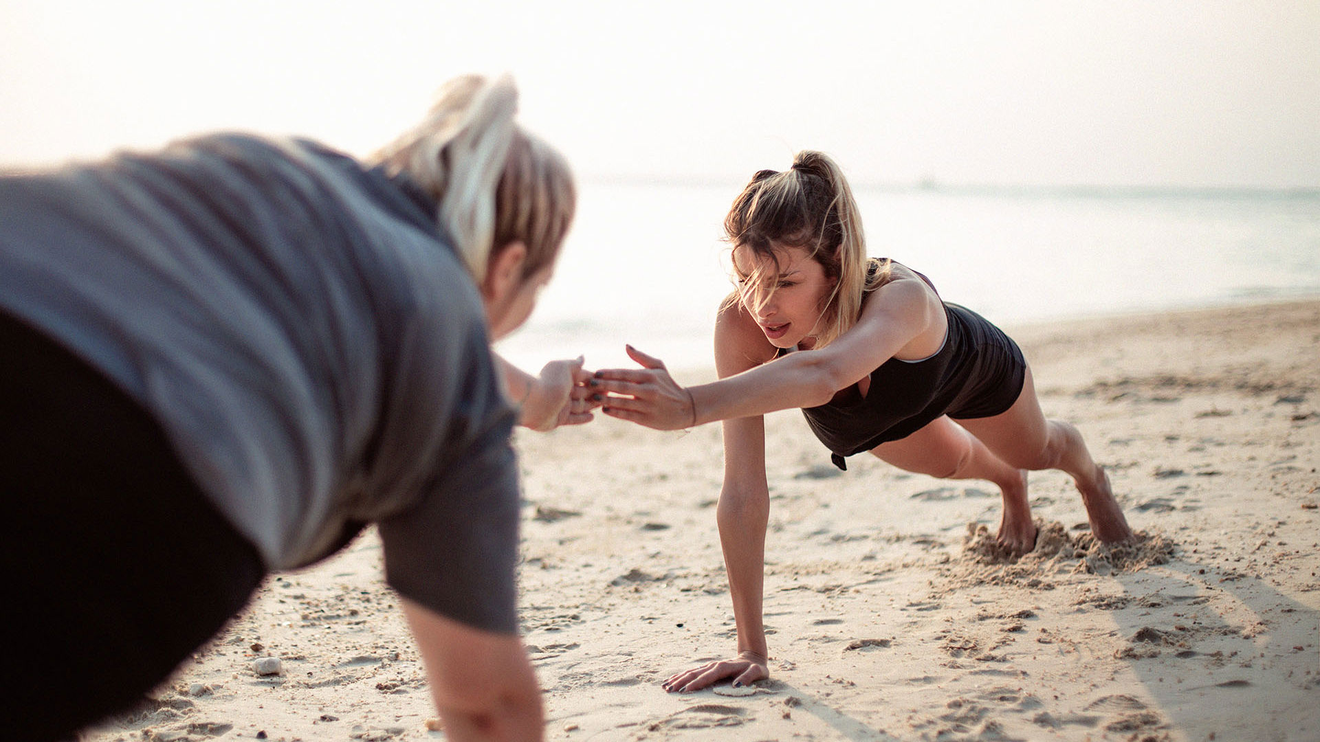 Women exercising on the beach